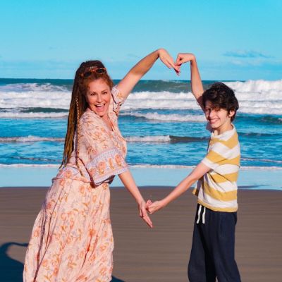 Simmone Jade Mackinnon and her son, Madigan James Mackinnon posing for a photo shoot while making an love sign using hands.
